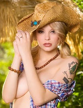 Foxy blonde cowgirl showing her weapons
